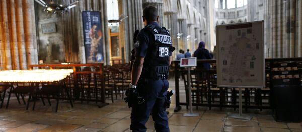 A policeman stands guard while people arrive for a Mass at the Rouen Cathedral, on July 27, 2016 in Rouen, to pay tribute to the priest Jacques Hamel, killed on July 26 in a church of Saint-Etienne-du-Rouvray during a hostage-taking claimed by Islamic State group A policeman stands guard while people arrive for a Mass at the Rouen Cathedral, on July 27, 2016 in Rouen, to pay tribute to the priest Jacques Hamel, killed on July 26 in a church of Saint-Etienne-du-Rouvray during a hostage-taking claimed by Islamic State group - Sputnik International