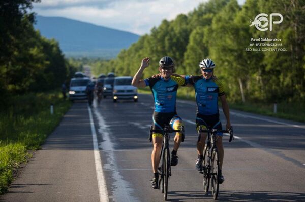 Matthias Fischer from Germany takes relay race from Martin Temmen from Germany during the 14th stage Khabarovsk-Vladivostok at the Red Bull Trans-Siberian Extreme race in Russia on July 27th, 2016 - Sputnik International