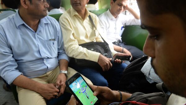 In this photograph taken on July 28, 2016 an Indian officegoer plays the Pokemon Go game on his phone while commuting in a local train in Mumbai - Sputnik International