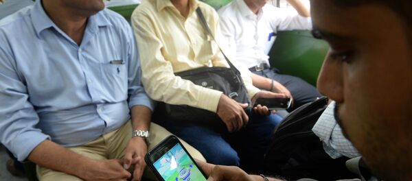 In this photograph taken on July 28, 2016 an Indian officegoer plays the Pokemon Go game on his phone while commuting in a local train in Mumbai In this photograph taken on July 28, 2016 an Indian officegoer plays the Pokemon Go game on his phone while commuting in a local train in Mumbai - Sputnik International