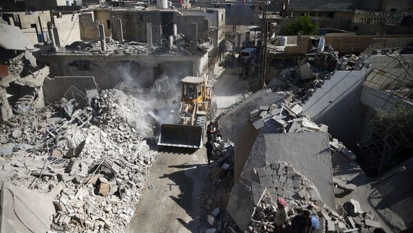 A front loader remove debris from a site hit by an airstrike in the rebel held Douma neighborhood of Damascus (File) - Sputnik International
