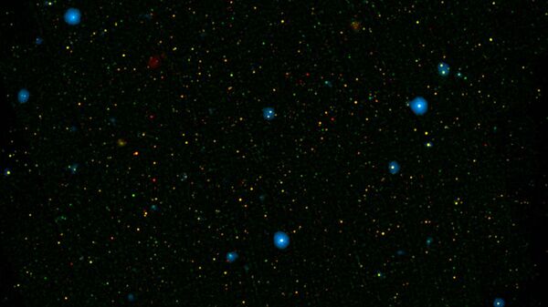 The blue dots in this field of galaxies, known as the COSMOS field, show galaxies that contain supermassive black holes emitting high-energy X-rays - Sputnik International