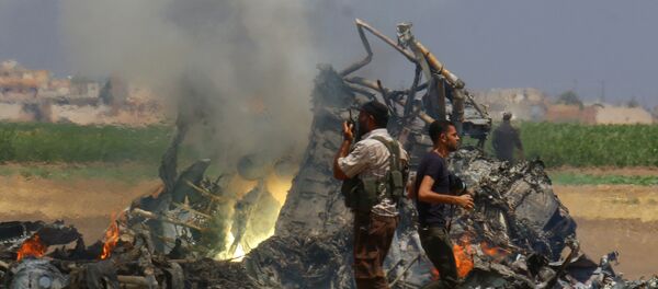 Men inspect the wreckage of a Russian helicopter that had been shot down in the north of Syria's rebel-held Idlib province, Syria - Sputnik International