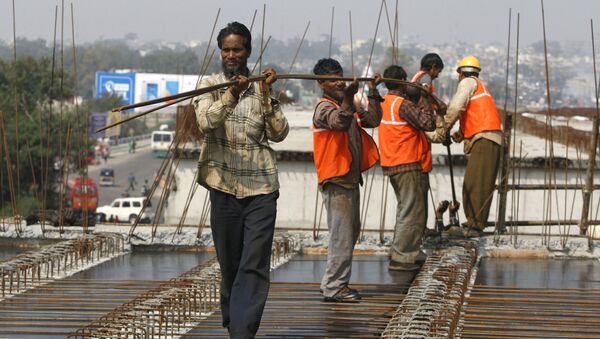 Indian workers carry metal rods on an overpass bridge in Jammu, India - Sputnik International