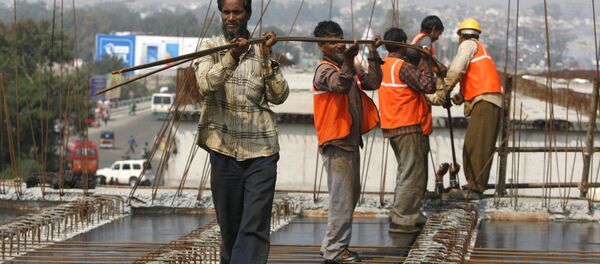 Indian workers carry metal rods on an overpass bridge in Jammu, India - Sputnik International