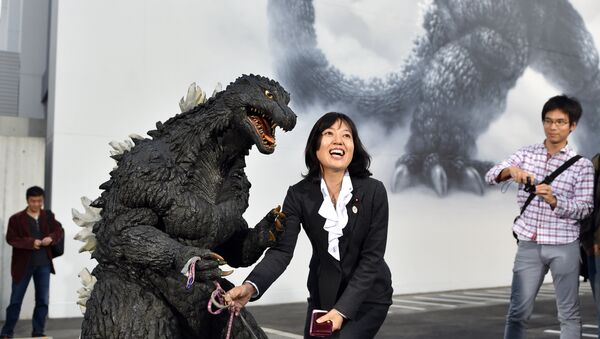 Japan's star monster Godzilla (front L) celebrates with a fan after an awards ceremony at Toho Studio in Tokyo's Setagaya Ward on November 3, 2014. - Sputnik International