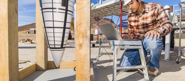 Tyler Keil, Sandia National Laboratories lead engineer for a test series using Sandia’s Davis gun, performs a final diagnostics check on a data recorder for an impact test on the nose assembly of a mock B61-12 - Sputnik International