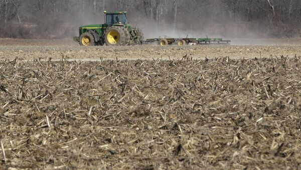 In this photo taken Thursday, Jan. 30, 2014, a farmer takes advantage of dry weather to till a field in preparation for spring planting near England, Ark. - Sputnik International