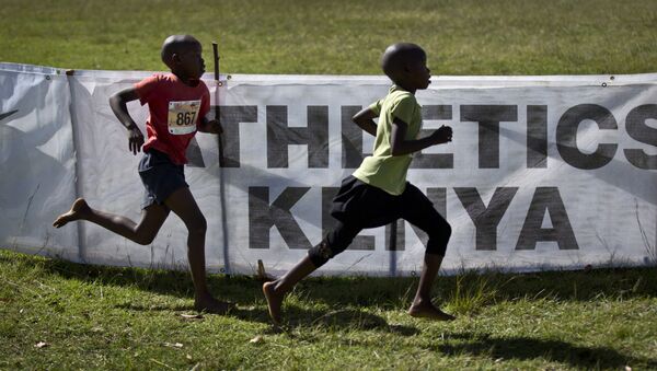 In this photo taken Sunday, Jan. 31, 2016, junior athletes run past a sign for Athletics Kenya at the Discovery cross country races in Eldoret, western Kenya - Sputnik International