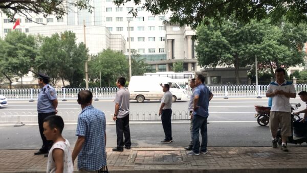 Chinese policemen in plain clothes stand as they stop journalists from taking pictures and video footage in front of the Number 2 Intermediate People's Court in Tianjin on August 4, 2016 - Sputnik International