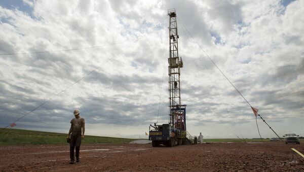 In this Tuesday, July 26, 2011 file photo, Austin Mitchell walks away from an oil derrick outside of Williston, N.D. - Sputnik International