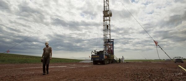 In this Tuesday, July 26, 2011 file photo, Austin Mitchell walks away from an oil derrick outside of Williston, N.D. - Sputnik International