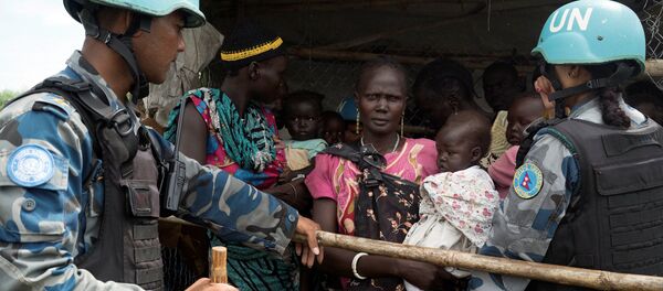United Nations peacekeepers control South Sudanese women and children before the distribution of emergency food supplies at the United Nations protection of civilians (POC) site 3 hosting about 30,000 people displaced during the recent fighting in Juba, South Sudan, July 25, 2016 - Sputnik International