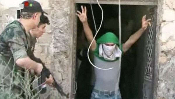 This still image from Syrian state TV video, shows a young man with his face covered surrendering to government forces, in Aleppo, Syria, Saturday, July 30, 2016 - Sputnik International