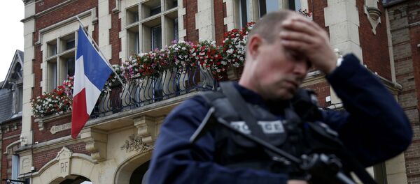 A policeman reacts as he secures a position in front of the city hall after two assailants had taken five people hostage in the church at Saint-Etienne-du -Rouvray near Rouen in Normandy, France, July 26, 2016 - Sputnik International