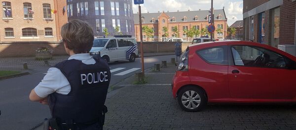 A photo taken with a mobile phone on August 6, 2016, shows a police officer standing guard close to a police building in the southern Belgian city of Charleroi following a machete attack A photo taken with a mobile phone on August 6, 2016, shows a police officer standing guard close to a police building in the southern Belgian city of Charleroi following a machete attack - Sputnik International