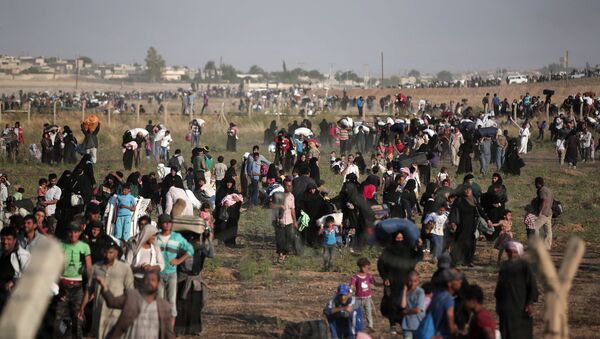 In this June 14, 2015 file photo taken from the Turkish side of the border between Turkey and Syria, in Akcakale, Sanliurfa province, southeastern Turkey, thousands of Syrian refugees walk in order to cross into Turkey - Sputnik International