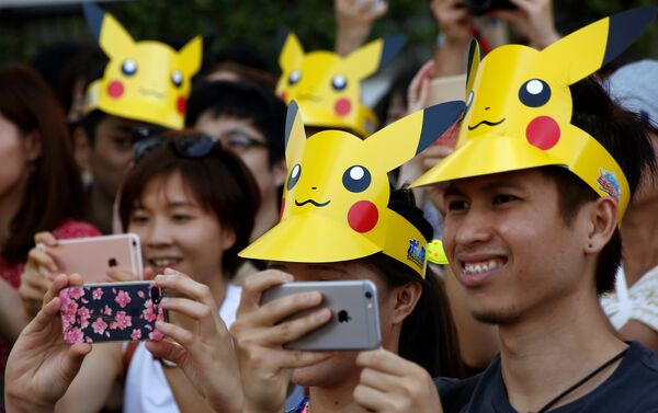 People wearing 'Pikachu' hats take pictures of the parade by performers wearing Pokemon's character Pikachu costumes in Yokohama, Japan - Sputnik International