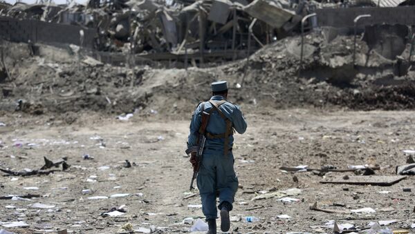 FILE - In this Monday, Aug. 1, 2016 file photo, an Afghan Security policeman inspects the site of a suicide truck bombing, in Kabul, Afghanistan. - Sputnik International