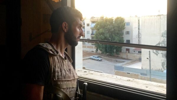 A Syrian Army soldier examines a position from an apartment window in southern Aleppo - Sputnik International