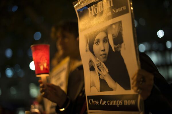 A participant holds portrait of a Somali refugee, who set herself on fire on the remote Pacific island of Nauru, during a candle light vigil in Sydney on May 4, 2016 A participant holds portrait of a Somali refugee, who set herself on fire on the remote Pacific island of Nauru, during a candle light vigil in Sydney on May 4, 2016 - Sputnik International