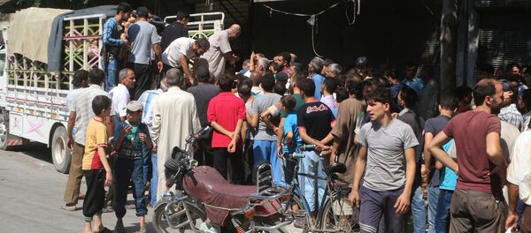 People gather to get fresh produce that was brought into rebel held areas of Aleppo by private traders from a newly opened corridor that linked besieged opposition held eastern Aleppo with western Syria that was captured recently by rebels, in Aleppo, August 11, 2016 - Sputnik International
