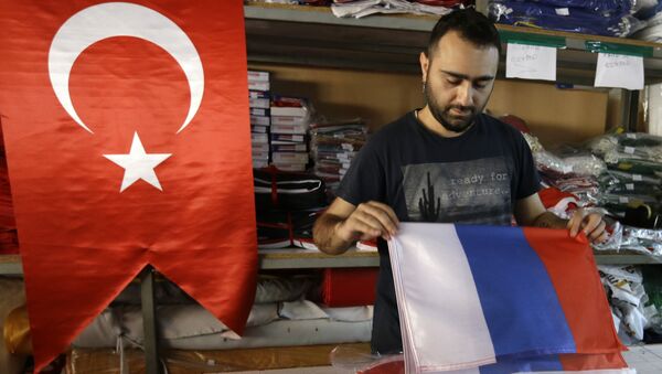 An employee of a flag-making factory folds a Russian flag as a Turkish flag adorns the display at left, in Istanbul, Tuesday, Aug. 9, 2016 - Sputnik International