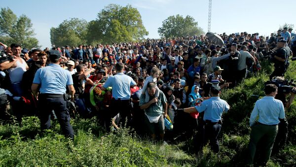 Policemen direct migrants during a stampede to board a bus in Tovarnik, Croatia September 17, 2015 - Sputnik International
