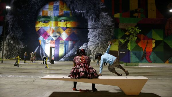 2016 Rio Olympics - Locals sit in front of a mural created by Brazilian artist Eduardo Kobra that covers nearly 3,000 square meters of wall space Rio de Janeiro, Brazil - Sputnik International