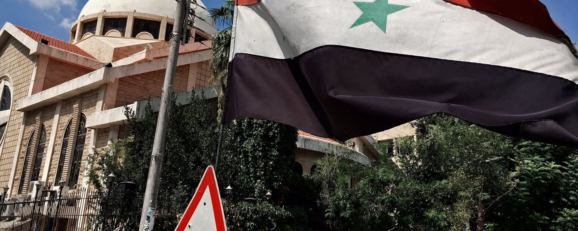 A state flag of the Syrian Arab Republic by an Orthodox church in an old Christian block of Aleppo, Syria - Sputnik International, 1920, 30.04.2023