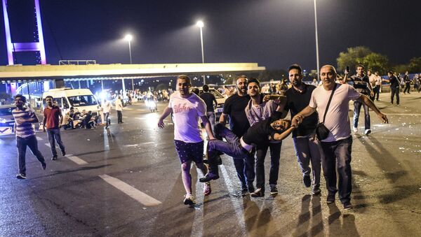 People carry a man shot during clashes with Turkish military at the entrance to the Bosphorus bridge in Istanbul on July 16, 2016 - Sputnik International