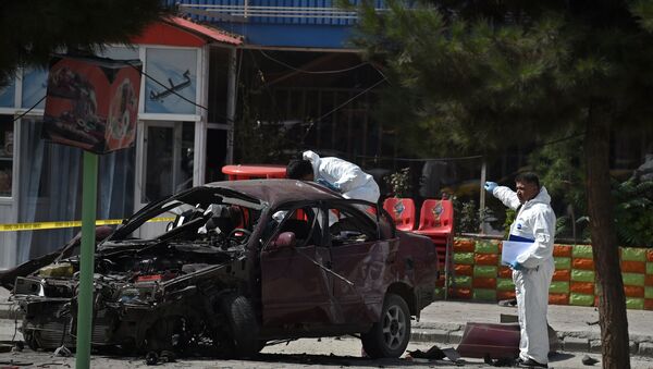 Afghan security personnel inspect a damaged car at the site of a suicide bomb attack near the US embassy in Kabul on August 15, 2016 - Sputnik International