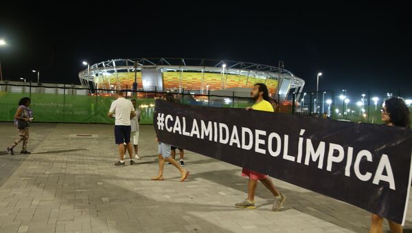 Protesters carry banner with a #Calamidadeolímpica hashtag (#OlympicCalamity). - Sputnik International