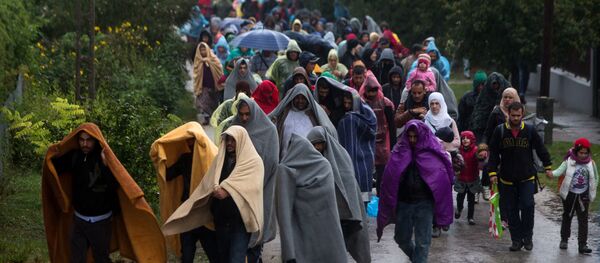 Refugees walk from railway station in Hegyeshalom in Hungary toward the Austrian border. Refugees walk from railway station in Hegyeshalom in Hungary toward the Austrian border. - Sputnik International