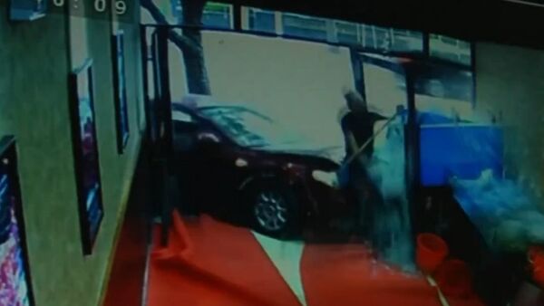 Car crashes into shop window knocking down cleaner - Sputnik International