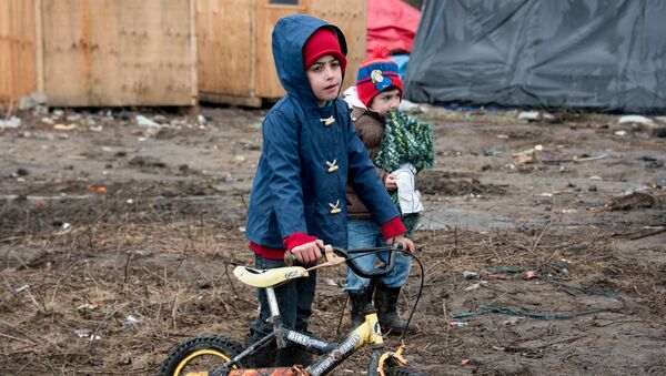 Migrant children play in the southern part of the so-called 'Jungle' migrant camp in Calais, northern France - Sputnik International