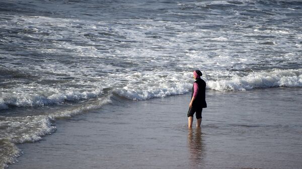 A Moroccan woman wearing a burkini, a full-body swimsuit designed for Muslim women, enters the sea at Oued Charrat beach, near the capital Rabat - Sputnik International