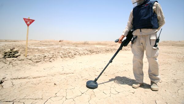 An Iraqi man wearing protective gear searches for landmines in the Shalamja border crossin, west of Basra, on the border between Iraq and Iran - Sputnik International