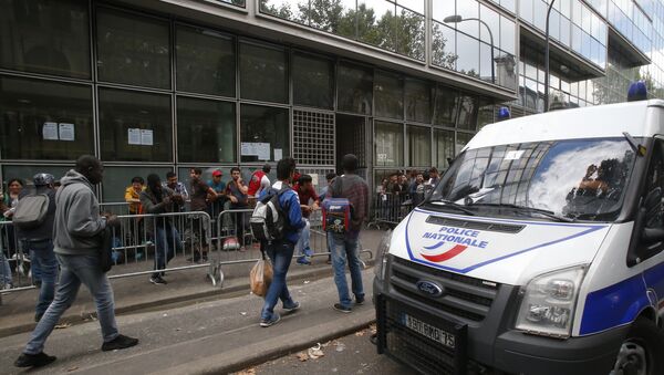 A police van parks as refugees queue outside a refugees center in Paris - Sputnik International