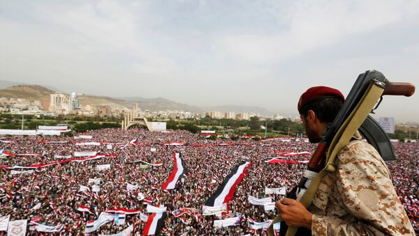 A soldier looks at people rallying to show support to a political council formed by the Houthi movement and the General People's Congress party to unilaterally rule Yemen by both groups, in the capital Sanaa August 20, 2016 - Sputnik International