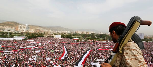 A soldier looks at people rallying to show support to a political council formed by the Houthi movement and the General People's Congress party to unilaterally rule Yemen by both groups, in the capital Sanaa August 20, 2016 - Sputnik International