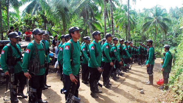 In this file photograph taken on December 26, 2009, New People's Army (NPA) rebels stand to attention during the 41st founding anniversary of the Communist Party of the Philippines at an unspecified location in the hinterlands of Surigao del Sur province, in the southern Philippine island of Mindanao. - Sputnik International