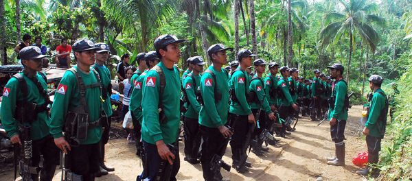 In this file photograph taken on December 26, 2009, New People's Army (NPA) rebels stand to attention during the 41st founding anniversary of the Communist Party of the Philippines at an unspecified location in the hinterlands of Surigao del Sur province, in the southern Philippine island of Mindanao. - Sputnik International