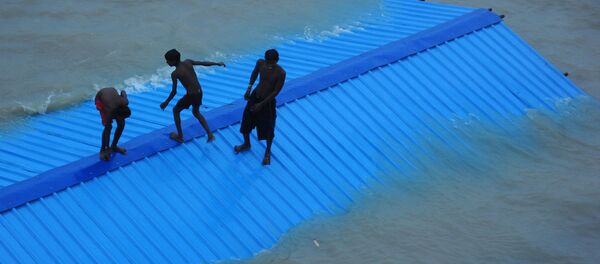 Indian children of local boatmen sit on the top of a submerged restroom at Daraganj Ghat as they prepare to jump into the flooded Ganga river in Allahabad on August 18, 2016 - Sputnik International