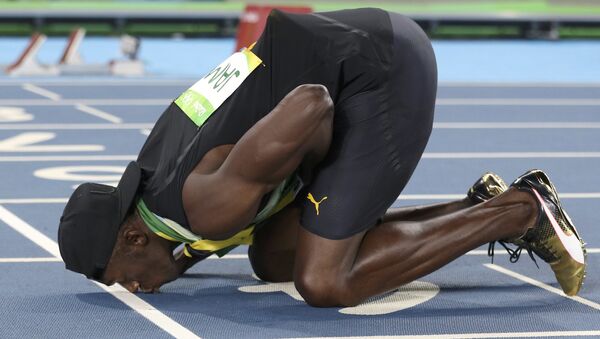 2016 Rio Olympics - Athletics - Final - Men's 4 x 100m Relay Final - Olympic Stadium - Rio de Janeiro, Brazil - 19/08/2016. Usain Bolt (JAM) of Jamaica kisses the track after his team won the gold - Sputnik International