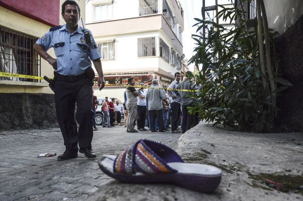 A Turkish policeman stands next to a shoe near the explosion scene behind police cordon following a late night attack on a wedding party that left at least 30 dead in Gaziantep in southeastern Turkey near the Syrian border on August 21, 2016 - Sputnik International