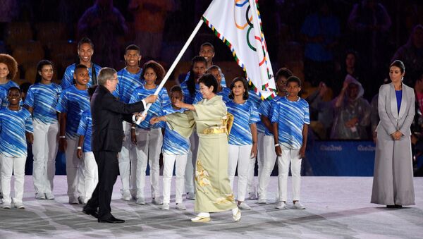 International Olympic Committee (IOC) President Thomas Bach (L) gives the Olympic flag to Tokyo's governor Yuriko Koike during the closing ceremony of the Rio 2016 Olympic Games at the Maracana stadium in Rio de Janeiro on August 21, 2016. - Sputnik International