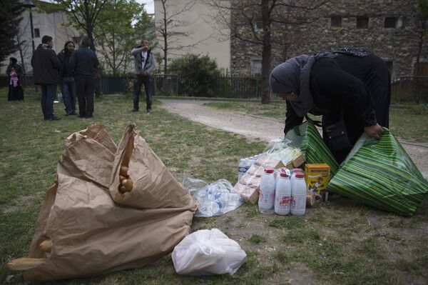 A Syrian refugee woman packs food on April 21, 2014 in the Edouard Vaillant park in Saint-Ouen, north of Paris, where the refugees spend most of their days awaiting to find housing solutions A Syrian refugee woman packs food on April 21, 2014 in the Edouard Vaillant park in Saint-Ouen, north of Paris, where the refugees spend most of their days awaiting to find housing solutions - Sputnik International