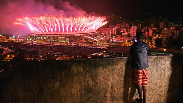 A boy from Mangueira favela watch fireworks over Maracana Stadium during the 2016 Olympics closing ceremony in Rio de Janeiro on August 21, 2016 - Sputnik International