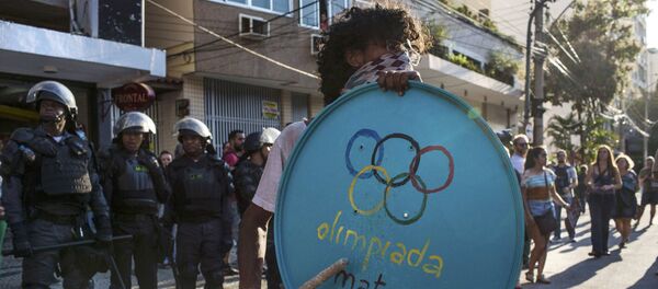 016 Rio Olympics - Opening Ceremony - Maracana - Rio de Janeiro, Brazil - 05/08/2016. Protester stands in front of riot police during demonstration against the Olympic Games near the Maracana stadium 016 Rio Olympics - Opening Ceremony - Maracana - Rio de Janeiro, Brazil - 05/08/2016. Protester stands in front of riot police during demonstration against the Olympic Games near the Maracana stadium - Sputnik International